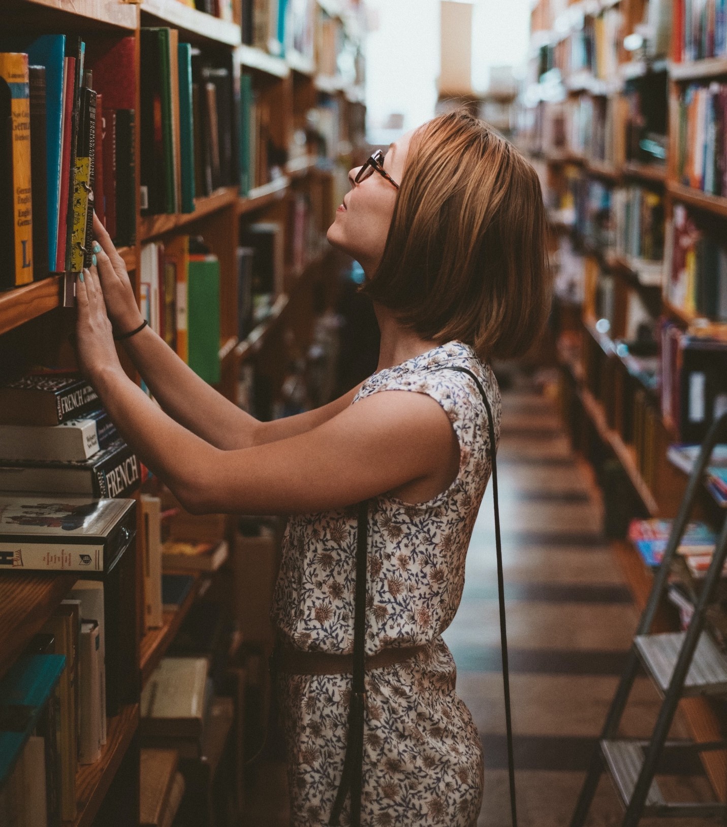 picture of a woman in a library looking at a book