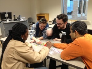 picture of four students working together on a project at a table