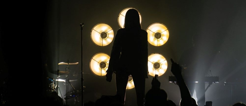 picture of woman backlit by spotlight at a concert