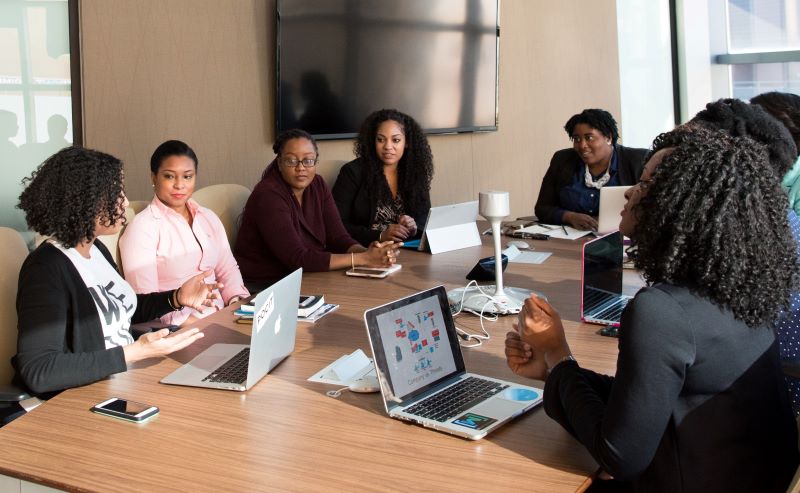 photo of women around a conference room table during a meeting