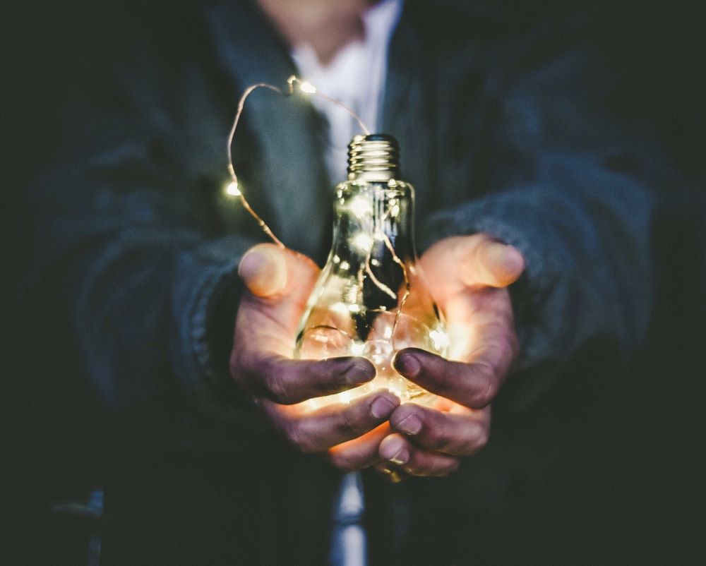 picture of dirty hands holding a edison lightbulb