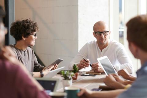 picture of 4 people sitting around a table talking