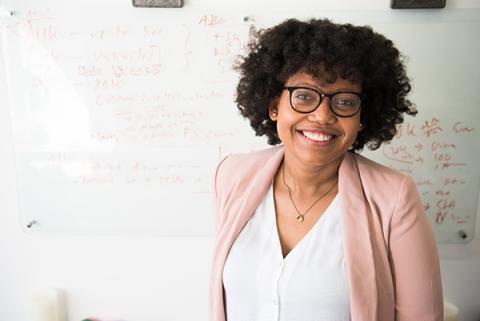 picture of woman smiling in front of a whiteboard
