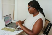 picture of a woman with a laptop looking at charts