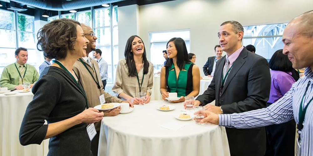 picture of people standing around table networking