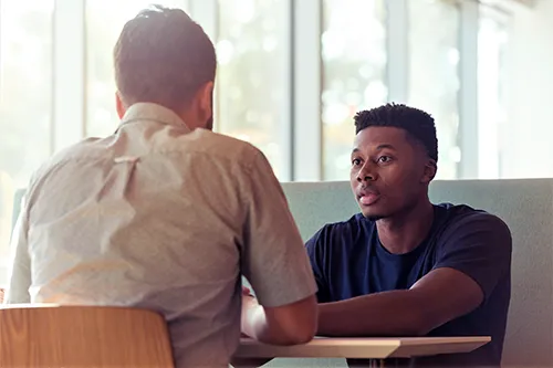 two people at a table talking