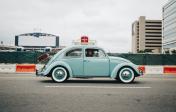 picture of a small blue VW Bug car on a city street