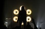 picture of woman backlit by spotlight at a concert