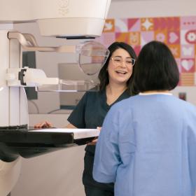 Nurse standing at mammogram machine