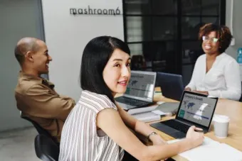 three staff working on laptops