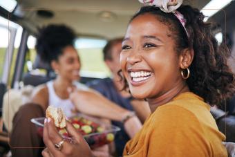 Preventive Care - woman in van with friends, smiling and eating a hamburguer