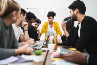 manager woman leading brainstorming meeting around a table