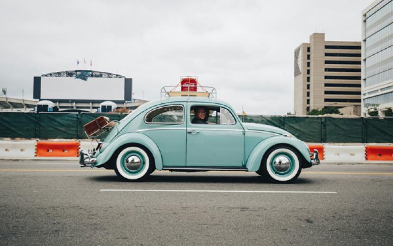 picture of a small blue VW Bug car on a city street