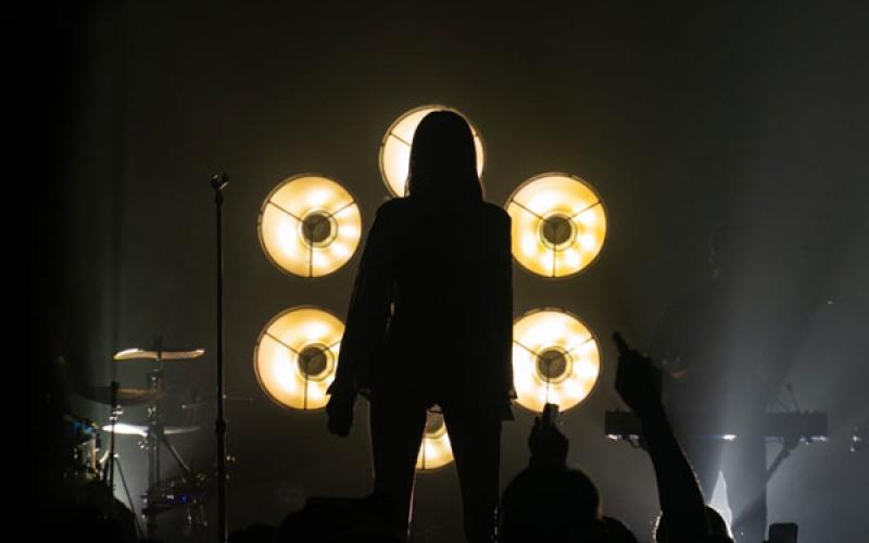 picture of woman backlit by spotlight at a concert