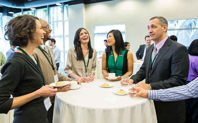 picture of people standing around table networking